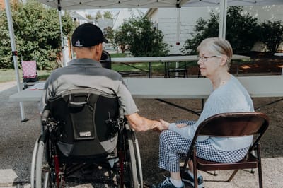 Two residents holding hands in an outdoor space