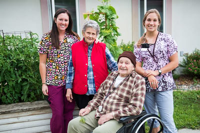 Residents and staff in a garden setting