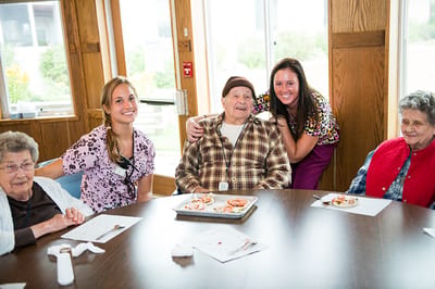Residents and staff enjoying a meal at a dining table