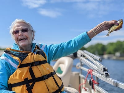 Senior resident joyfully fishing on a boat