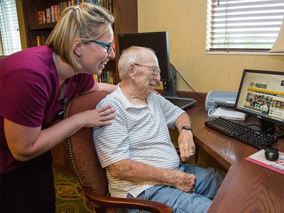 Staff assisting a resident with a computer