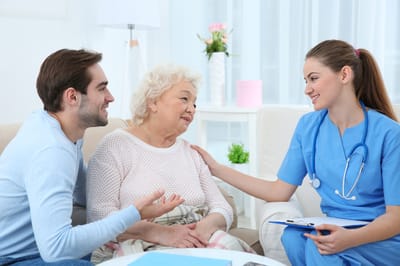 A caregiver interacting with a resident and family member