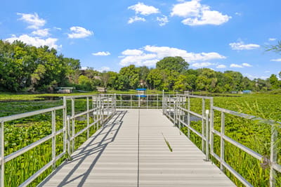 A scenic view of a wooden pier surrounded by greenery
