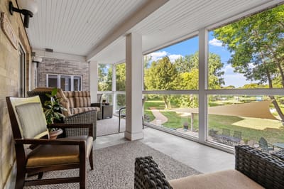 Covered outdoor seating area overlooking a landscaped garden