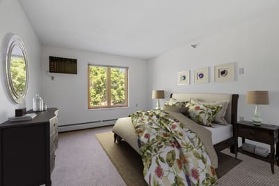 Brightly lit bedroom with floral bedding and furniture
