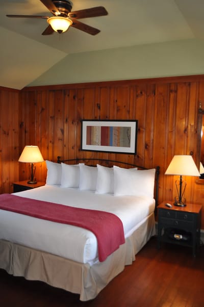 A cozy bedroom with wooden walls and a double bed
