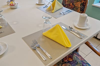 Dining table set with yellow napkins and glassware