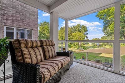 Screened porch with seating overlooking greenery