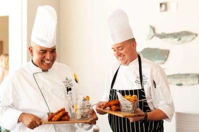 Chefs presenting freshly prepared food in a dining area