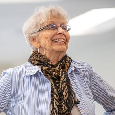 Smiling resident wearing a scarf in a bright room