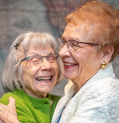 Two residents joyfully interacting in a community setting.