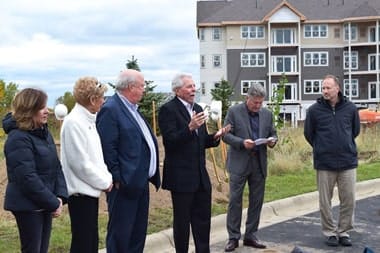Silvercrest Properties LLC, assisted living in St. Louis Park, MN — Groundbreaking ceremony with speakers and attendees in outdoor setting