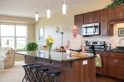 Resident in a bright kitchen with flowers and natural light