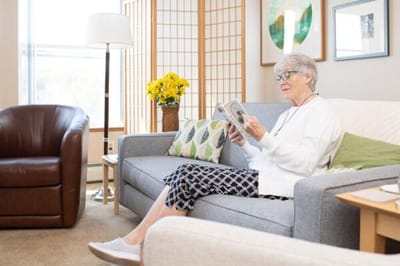 A resident enjoying reading in a cozy lounge area
