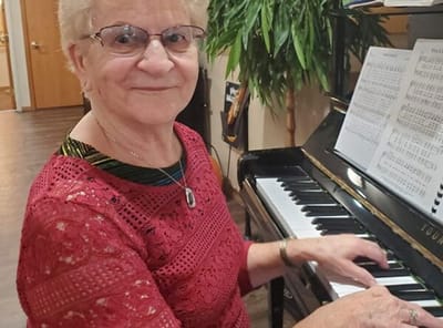 Senior resident playing piano in an activity room
