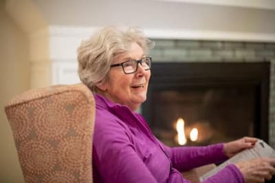 Resident enjoying a cozy moment by the fireplace