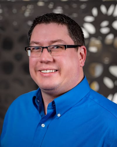 Smiling staff member in a blue shirt