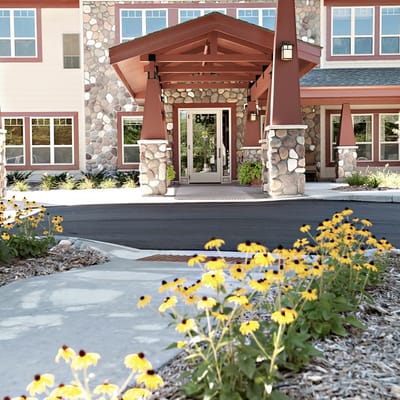 Front entrance of a senior living facility with flowers