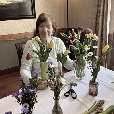 Resident arranging flowers at a table in common area