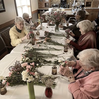 Residents creating flower arrangements in a common area