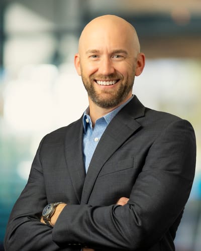 Smiling man in a suit with arms crossed