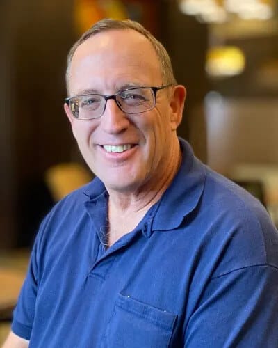 A smiling man in a blue polo shirt