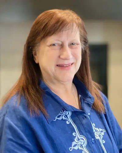 A smiling staff member in a blue shirt