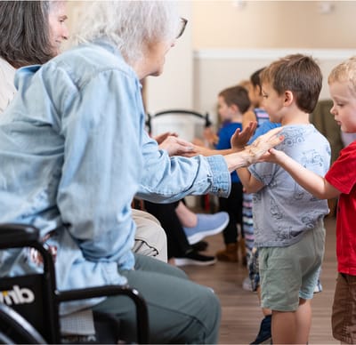 Residents engaging in a hands-on activity with young visitors