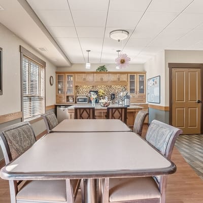 A cozy common area with kitchen and tables