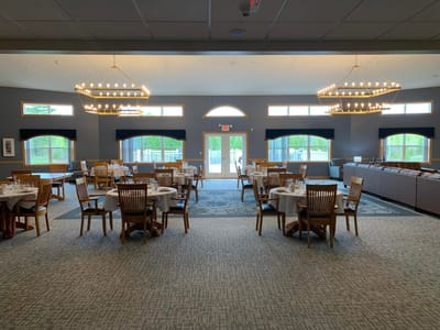 Straits Area Senior Living Community, assisted living in St. Ignace, MI — Dining area with tables and modern lighting fixtures