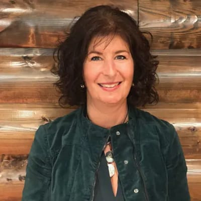 Woman smiling in front of a wooden background