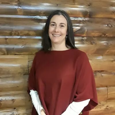 A woman smiling in a cozy indoor setting