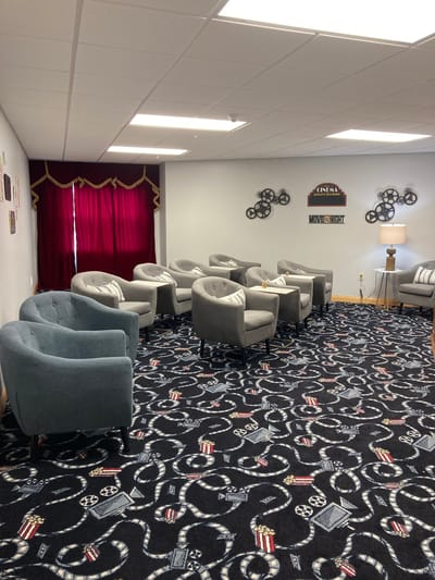 Straits Area Senior Living Community, assisted living in St. Ignace, MI — Cozy lounge area with grey chairs and decorative carpet