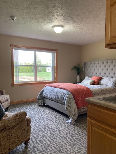 Straits Area Senior Living Community, assisted living in St. Ignace, MI — Cozy bedroom with a large window and armchair