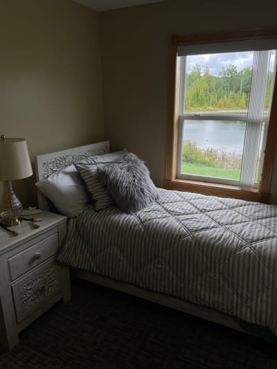 Straits Area Senior Living Community, assisted living in St. Ignace, MI — Cozy bedroom with a view of a lake
