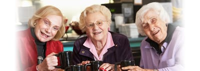 Three smiling women enjoying coffee together