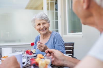 Resident enjoying a meal outdoors with fruit