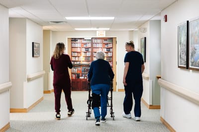 Staff assisting a resident in a hallway