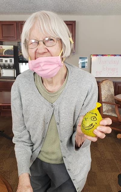 Resident engaging in a craft activity with a smile