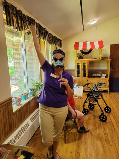 Staff member engaging with residents in an activity room