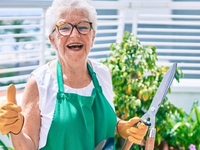 Senior resident gardening and smiling outdoors