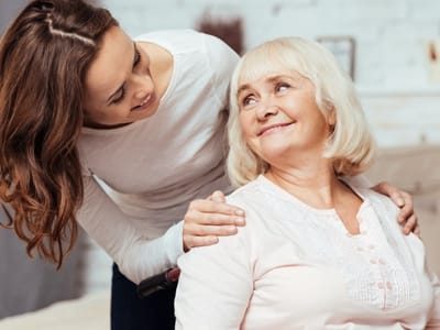 A caregiver smiling with a resident in a care setting