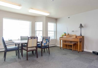 Bright common area with seating and a piano