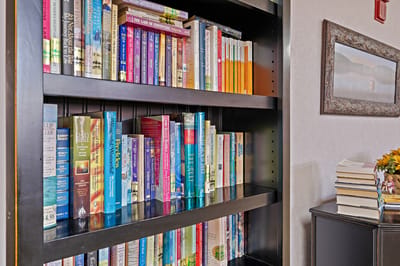 Bookshelf in a common area filled with various books