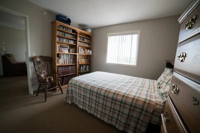 Private resident room with bookshelves and a bed
