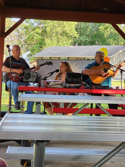 Musicians performing at a community gathering outdoors
