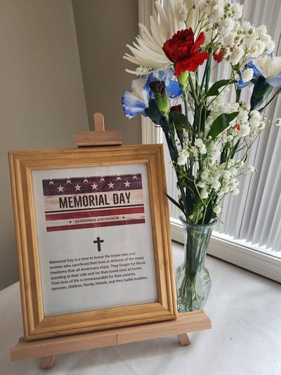 A Memorial Day display with flowers and a sign