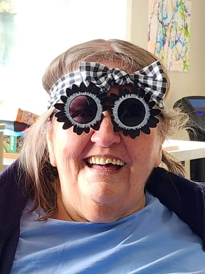 Resident wearing playful glasses and smiling