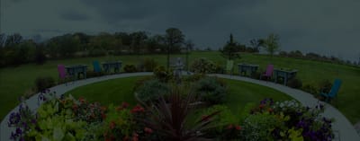 Well-maintained garden area with colorful chairs and plants