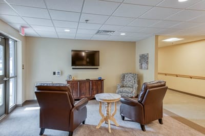 A cozy common area with seating and a TV.